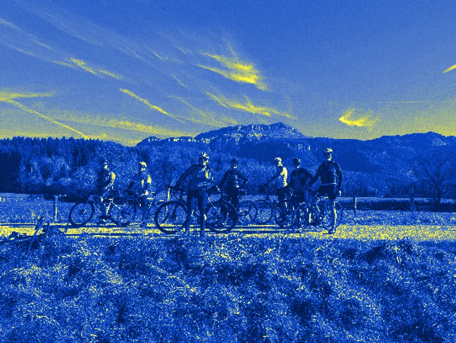 Une dizaine de cyclistes du club posent avec leurs vélos de route sur un chemin, devant les falaises calcaires de la Chartreuse, en automne.